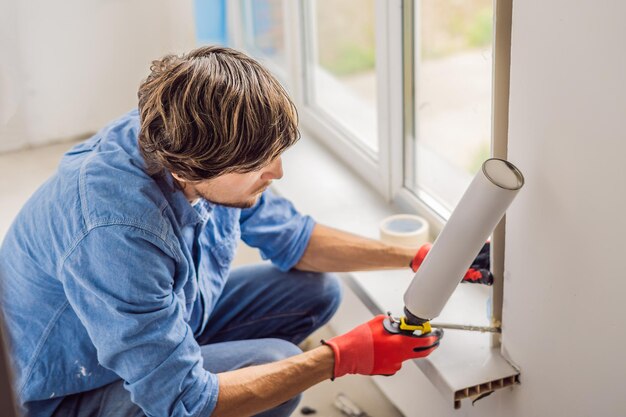 Mann in einem blauen Hemd macht Fensterinstallation.