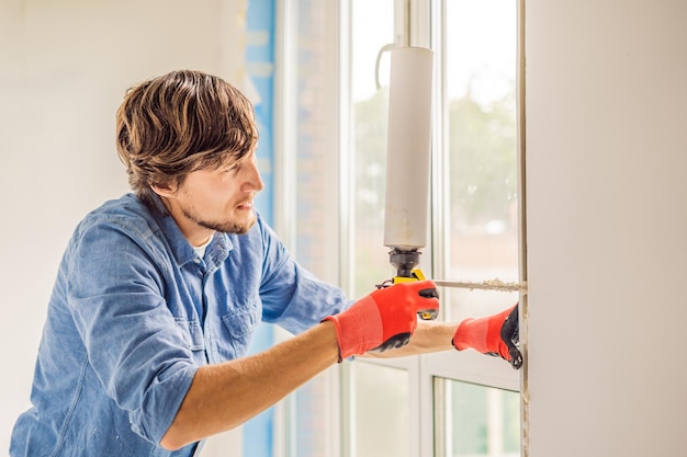 Mann in einem blauen Hemd macht Fensterinstallation.