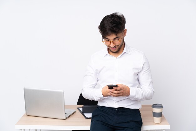 Mann in einem Büro, das am Telefon schaut