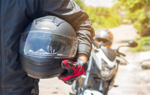 Mann in einem Motorrad mit Sturzhelm und Handschuhen ist Schutzkleidung für das Motorradfahren