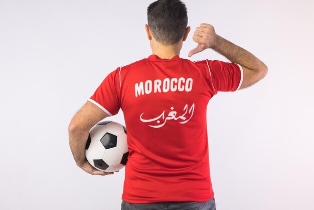 Mann in einem roten Hemd mit gedrehtem Rücken, der auf einige Buchstaben zeigt, die 39Marokko39 Sport-Weltmeisterschaft und Fan-Konzept lesen