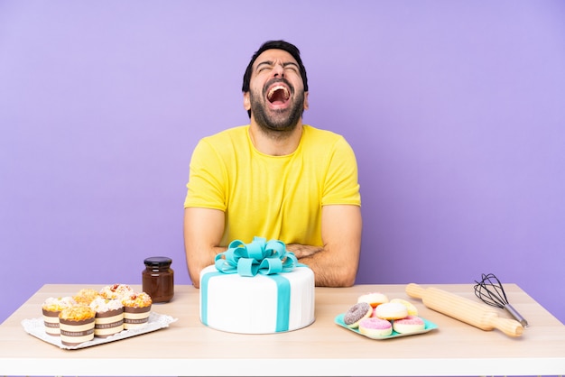 Mann in einem Tisch mit einem großen Kuchen, der nach vorne mit offenem Mund schreit