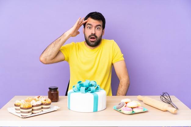 Mann in einem Tisch mit einem großen Kuchen hat gerade etwas realisiert und die Lösung beabsichtigt