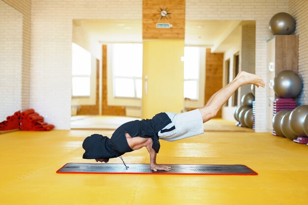 Mann in einer Haube, die Yoga praktiziert