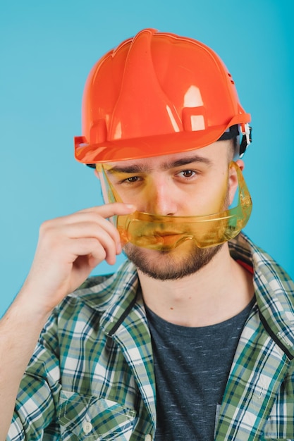 Mann in grünem Hemd und orangefarbenem Schutzhelm