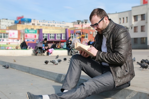 Foto mann in jacke und straßenlesebuch