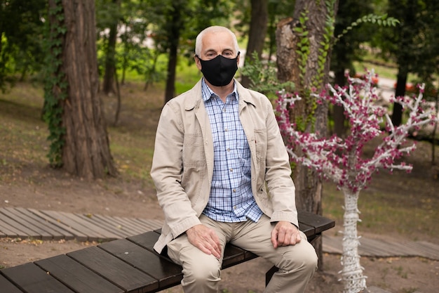 Mann in Maske im Park. Schutz vor der Krankheit.