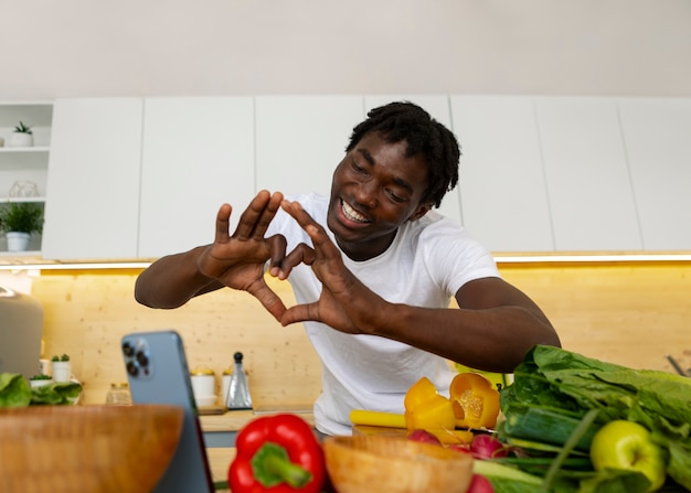 Foto mann in mittlerer aufnahme kocht mit smartphone