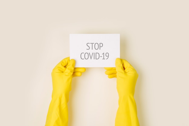 Mann in schutzhandschuhen hält ein warnplakat. die epidemie des coronavirus covind-19 2019-ncov. quarantäne, zu hause bleiben, von zu hause aus arbeiten.