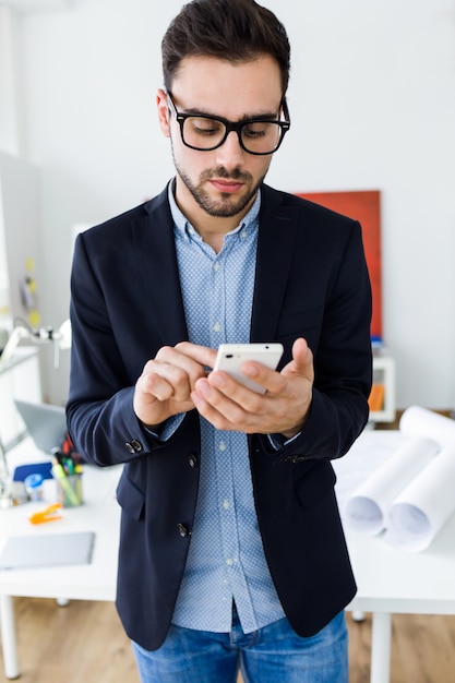 Mann in schwarz-umrandeten Brille, die ein Telefon