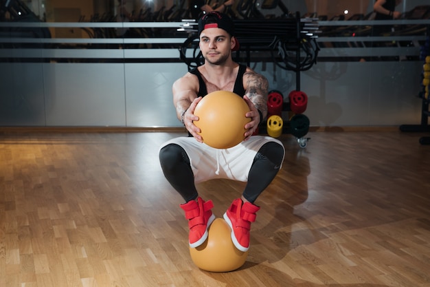 Foto mann in sportbekleidung trainiert im fitnessstudio