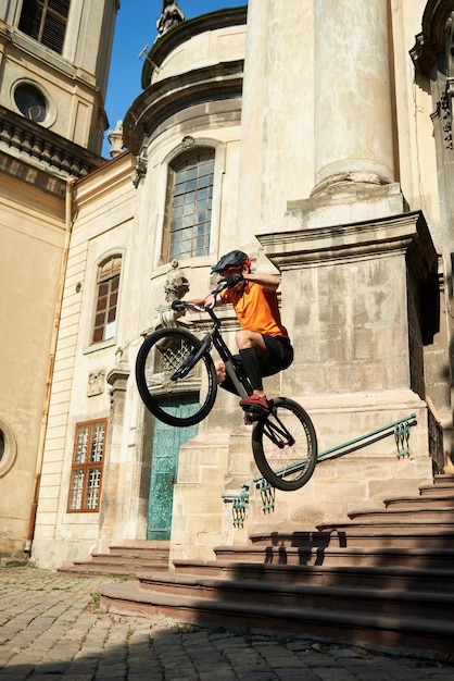 Mann in Sportkleidung, der von Stufen auf einem Fahrrad springt