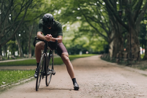 Mann in Sportkleidung macht Pause nach dem Radfahren im Park