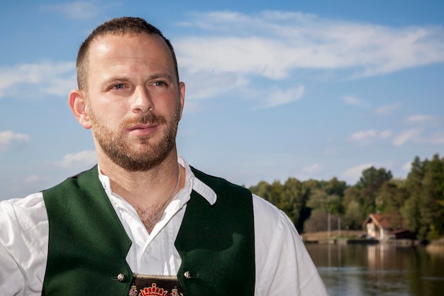 Mann in traditioneller Kleidung, der gegen den Himmel wegblickt