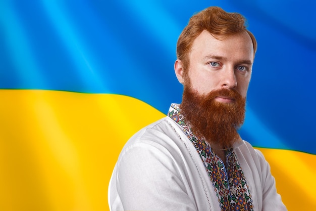 Mann in Vyshyvanka mit Flagge des ukrainischen Hintergrunds