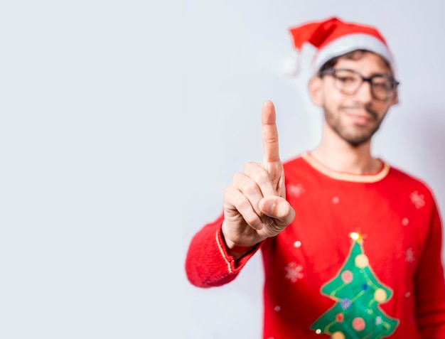 Mann in Weihnachtsmütze zählen Nummer eins mit Finger Mann in Weihnachtskostüm zählen Nummer eins mit Finger Konzept des Menschen in Weihnachtskostüm zählen Nummer eins isoliert