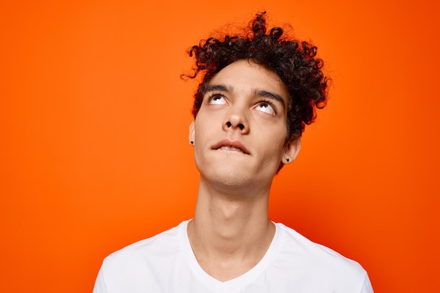 Mann in weißem T-Shirt, lockiges Haar, abgeschnittenes Studio, hochwertiges Foto