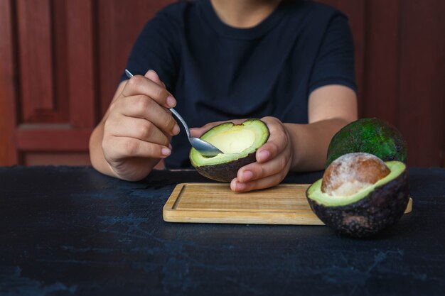 Mann isst eine Avocado mit einem sponn