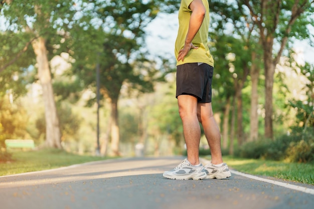 Mann joggt und geht morgens auf der Straße Erwachsener Mann in Sportschuhen läuft draußen im Park Trainieren Sie Wellness, gesunden Lebensstil und Wohlfühlkonzepte