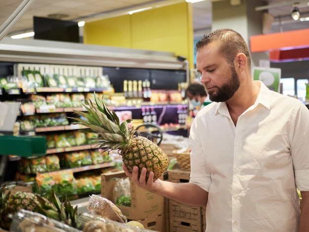 Foto mann kauft obst und gemüse im supermarkt