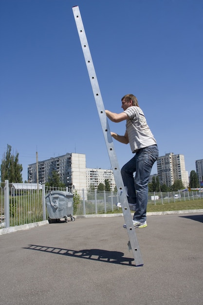 Mann klettert Leiter. Draußen