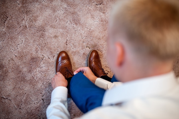 Foto mann knöpft seine eleganten schuhe zu