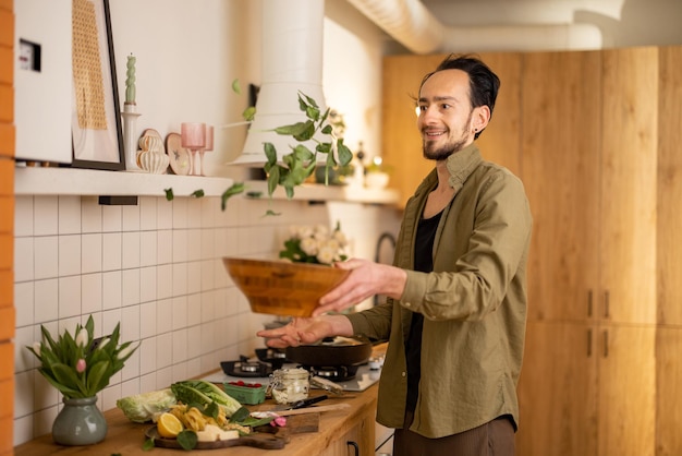 Mann kocht zu Hause gesund in der Küche