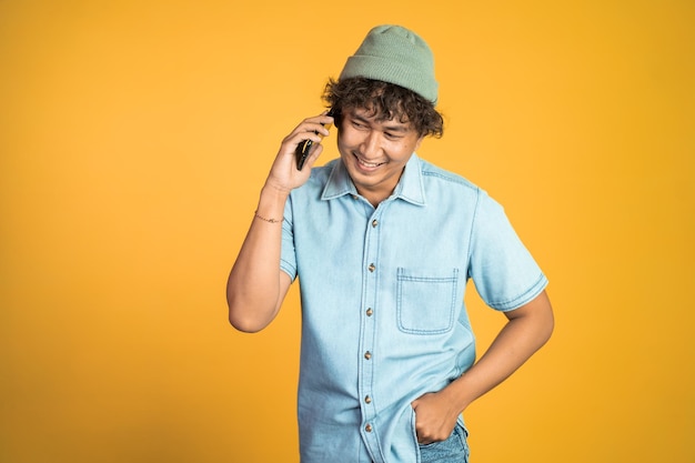 Mann lacht, während er auf isoliertem hintergrund telefoniert