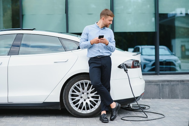 Mann lädt ein Elektroauto an der Ladestation