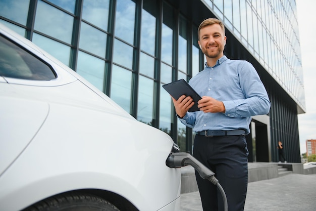 Mann lädt ein Elektroauto an der Ladestation