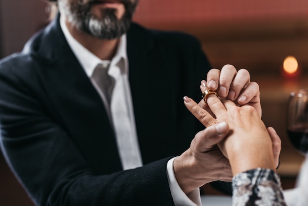 Foto mann legte ring an hand zu seiner frauennahaufnahme. konzentriere dich auf den ring