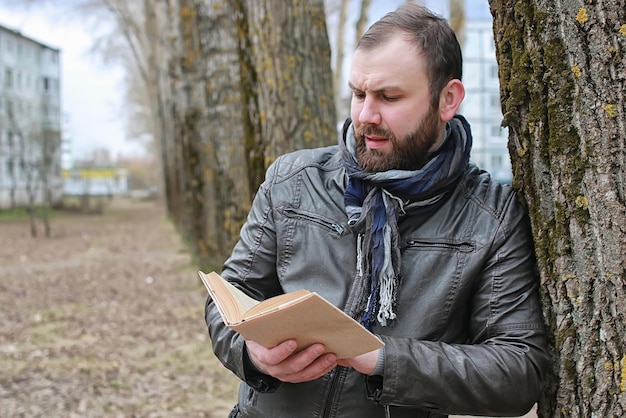 Mann liest Buch Baumpark