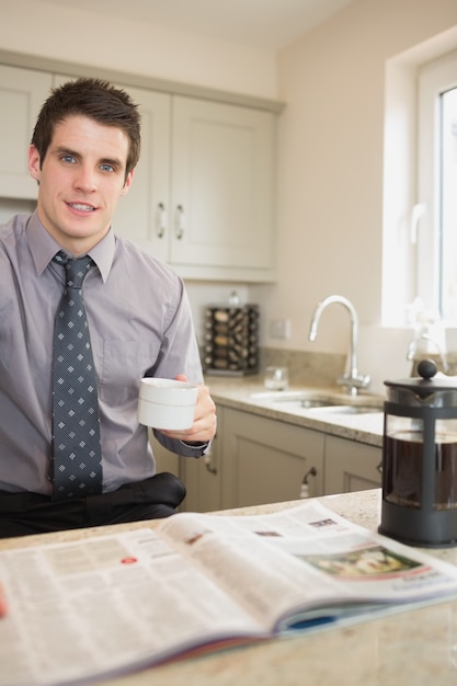 Mann liest Zeitung beim Kaffeetrinken