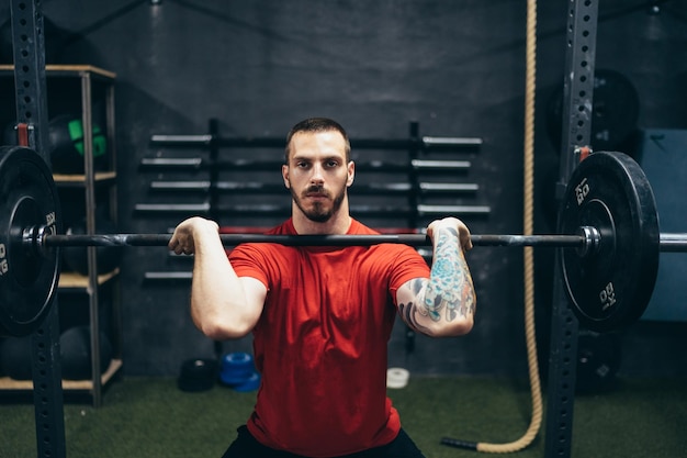 Mann macht eine Kniebeuge mit Gewichten in einem Fitnessstudio