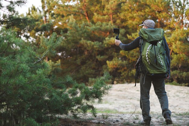 Mann macht Foto und Video von schönen Orten mit Stabilisator für Handy