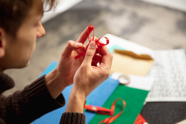 Mann macht Grußkarte für Neujahr und Weihnachten für Freunde oder Familie, Schrottbuchung, DIY