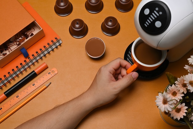 Mann macht heißen Kaffee mit Kaffeemaschine auf braunem Leder.