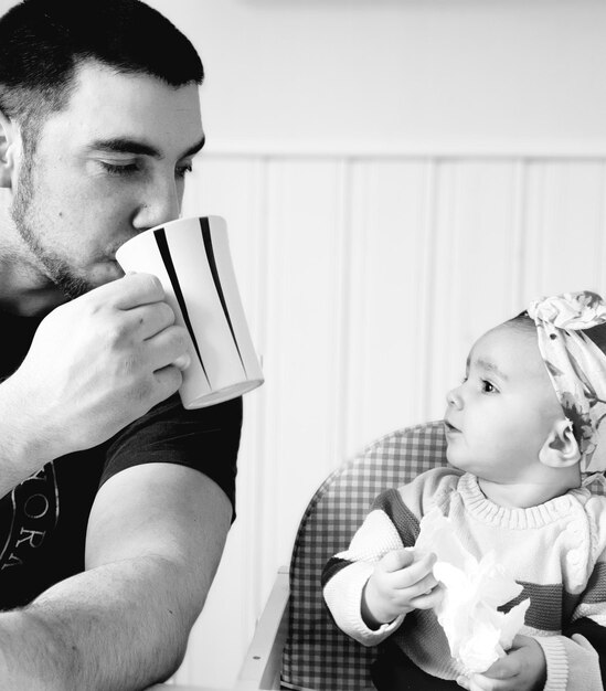 Foto mann mit baby trinkt zu hause kaffee