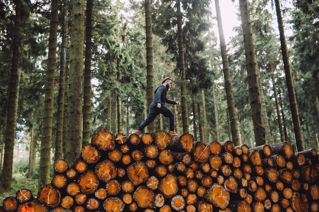 Mann mit Bart geht auf Holz im Wald