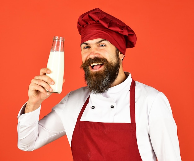 Mann mit Bart hält Glasflasche auf rotem Hintergrund