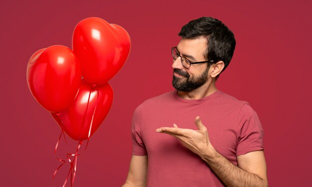 Mann mit Bart im Valentinstag über rotem Hintergrund