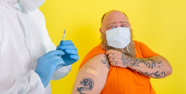 Mann mit Bart und Tattoos macht den Impfstoff gegen Covid