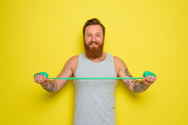 Mann mit Bart und Tattoos trainiert mit einem Gummiband