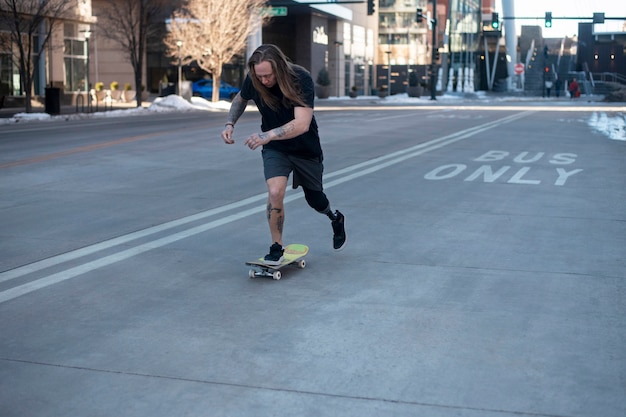 Foto mann mit beinbehinderung beim skateboarden in der stadt