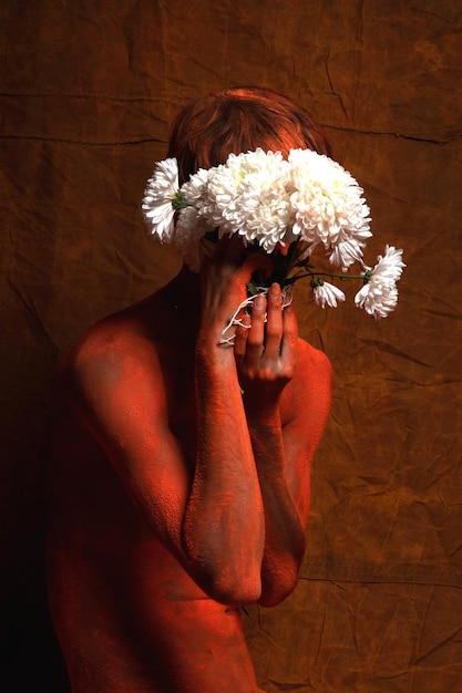 Mann mit Blumen steht an der Wand