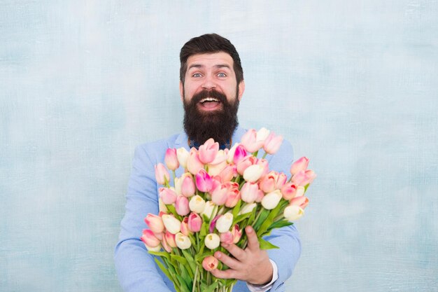 Mann mit Blumenstrauß. Frauentag. Formaler reifer Geschäftsmann. Frühling. 8. März. Braut Bräutigam bei Hochzeitsfeier. Liebes-Date. Alles Gute zum Geburtstag. bärtiger Mann in Fliege mit Tulpenblumen.