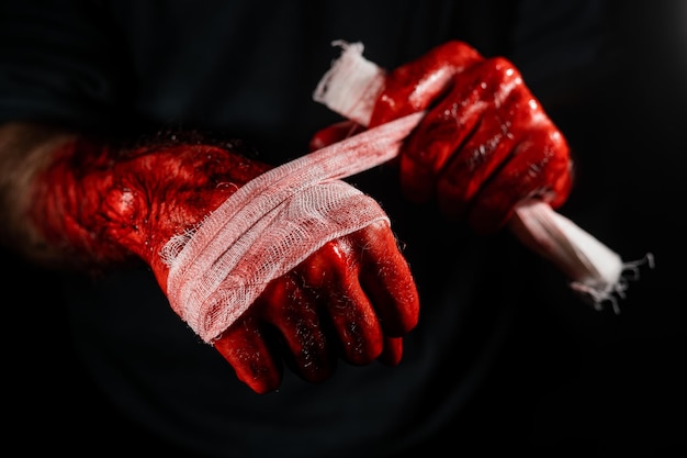 Foto mann mit blutigen händen mit einem verband