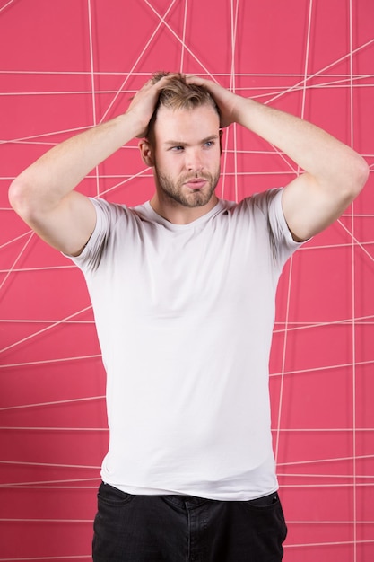 Foto mann mit borstenstrengem gesicht genießt die frische des haares, rosa hintergrund. haarpflegekonzept. kerl bärtig attraktiv mit frisur. mann mit bart oder unrasiertem kerl, gutaussehend und gut gepflegtes, berührendes haar.