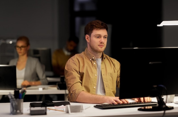 Foto mann mit computer arbeitet spät in der nacht im büro