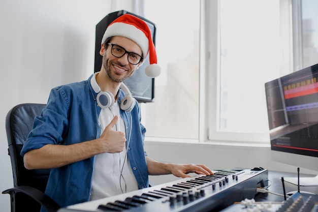 Mann mit der Weihnachtsmütze, die Klavier spielt